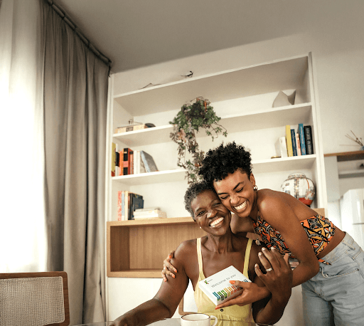 Two women smiling with a 23andMe DNA kit
