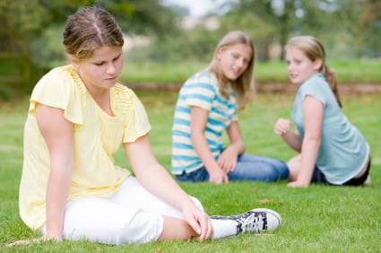 Two young girls bullying other young girl outdoors Two young girls bullying other young girl outdoors